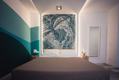 letto con carta da parati e illuminazione