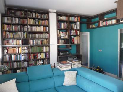 Parete libreria in legno con scala scorrevole